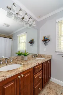 a bathroom with a granite countertop sink a large mirror and a window