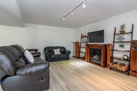 a living room with furniture a flat screen tv and a fireplace