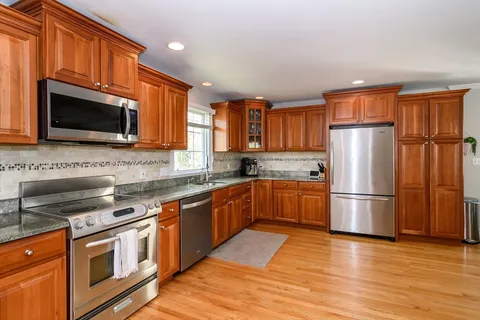 a kitchen with stainless steel appliances granite countertop a refrigerator microwave and sink