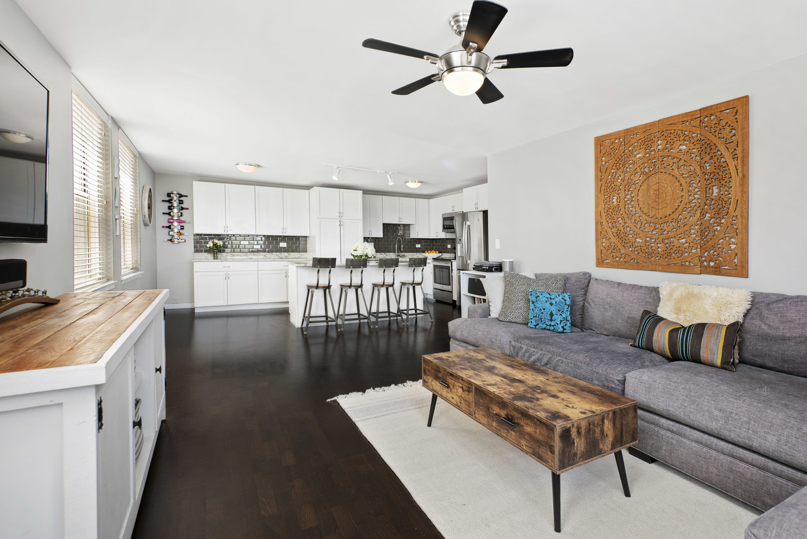 3033 North Sheridan Road, Unit 605 Chicago, IL 60657 - Photo 4 of 13 a living room with stainless steel appliances furniture a rug kitchen view and a chandelier