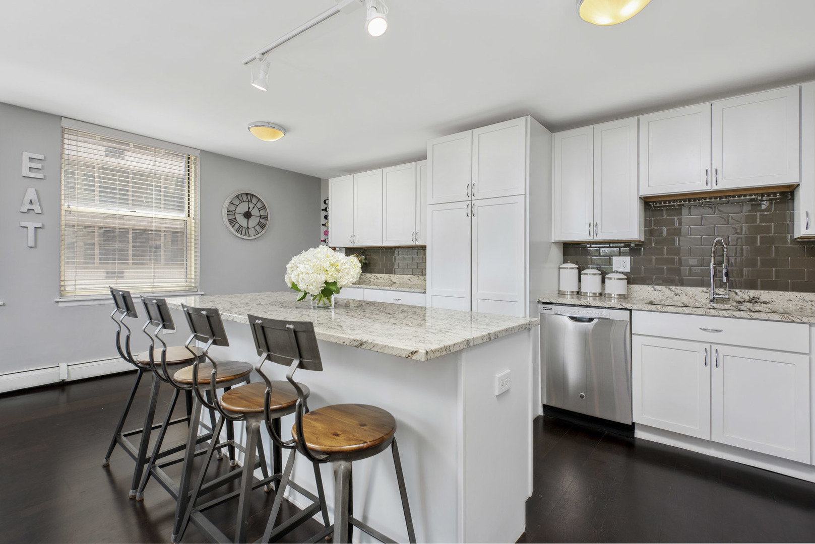 3033 North Sheridan Road, Unit 605 Chicago, IL 60657 - Photo 6 of 13 a kitchen with granite countertop white cabinets and chairs