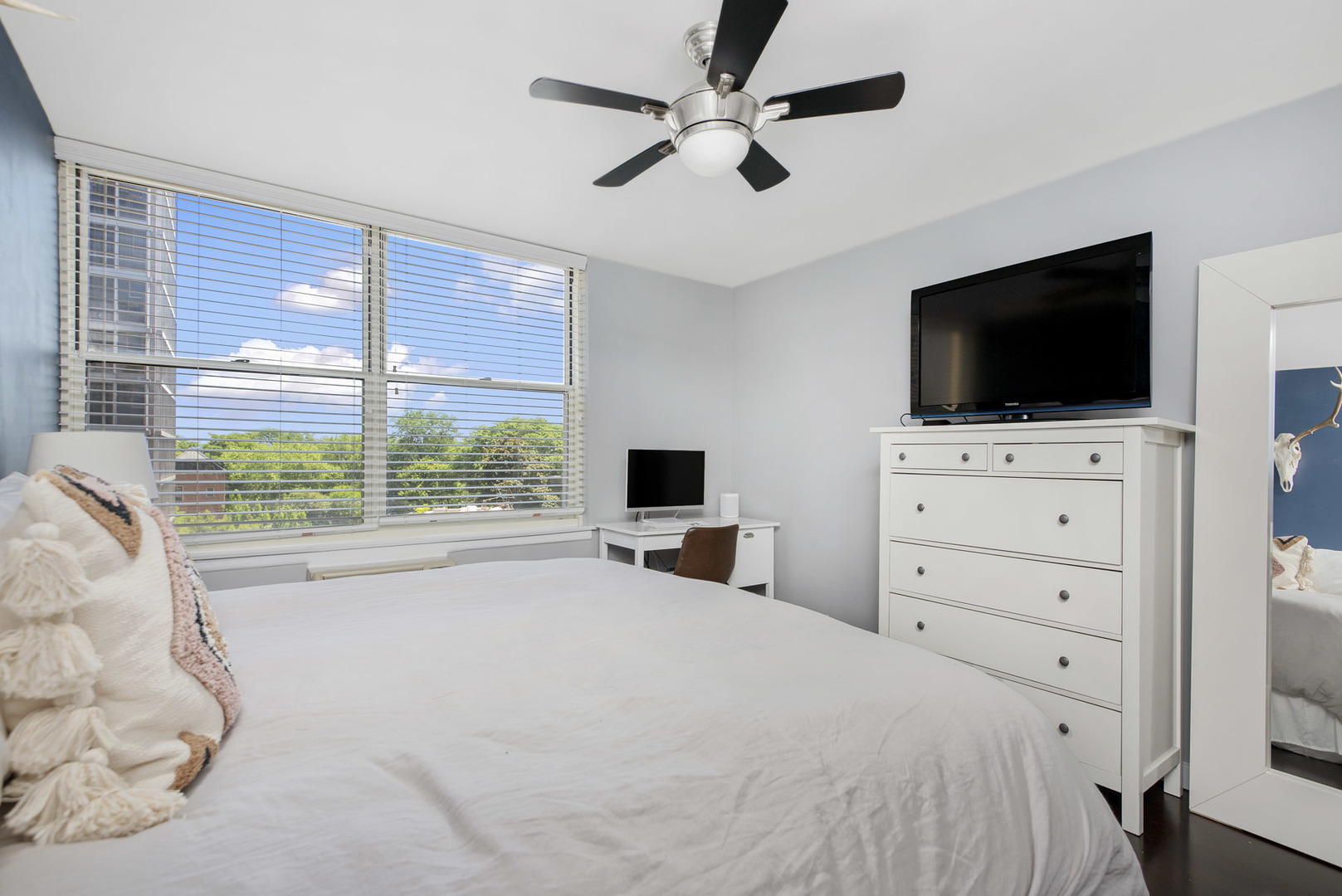 3033 North Sheridan Road, Unit 605 Chicago, IL 60657 - Photo 9 of 13 a bedroom with a bed a flat screen tv and a chandelier