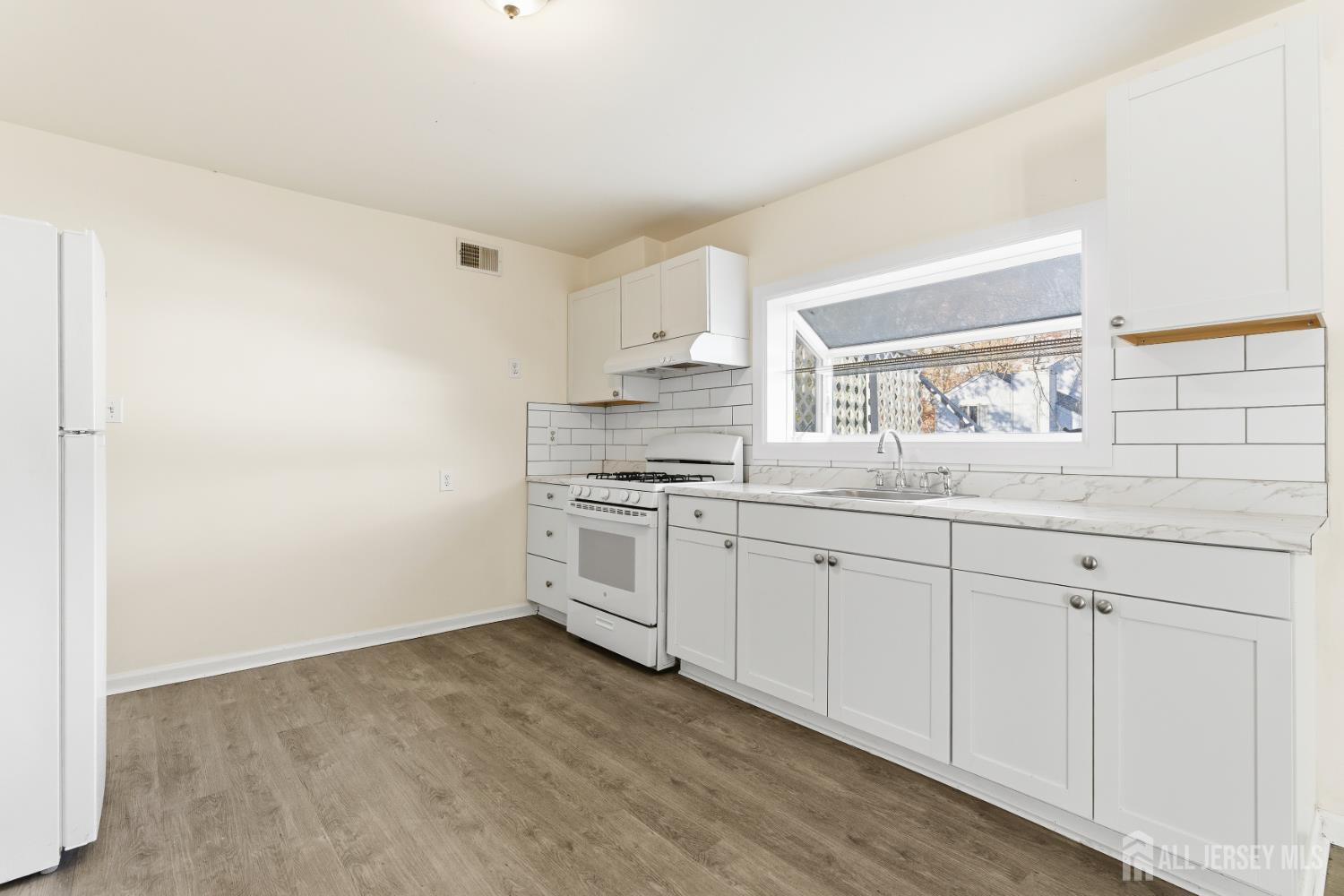 1818 Oak Tree Road Edison, NJ 08820 - Photo 10 of 15 a kitchen with granite countertop white cabinets and white appliances