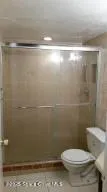a bathroom with a toilet and a shower
