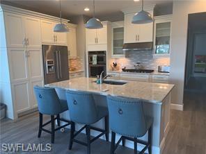 a kitchen with stainless steel appliances granite countertop a sink refrigerator and cabinets