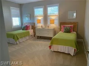 a bedroom with two beds and a window