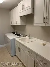 a utility room with sink dryer and washer