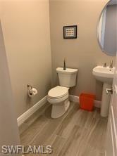 16390 Viansa Way, Unit 1202 Naples, FL 34110 - Photo 21 of 26 a bathroom with a toilet sink and mirror