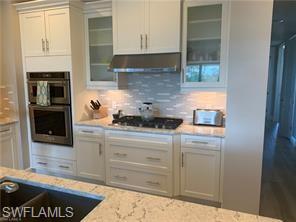 16390 Viansa Way, Unit 1202 Naples, FL 34110 - Photo 3 of 26 a kitchen with granite countertop a stove