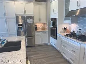 a kitchen with stainless steel appliances kitchen island granite countertop a refrigerator and a stove