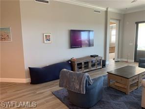 16390 Viansa Way, Unit 1202 Naples, FL 34110 - Photo 7 of 26 a living room with furniture and a flat screen tv