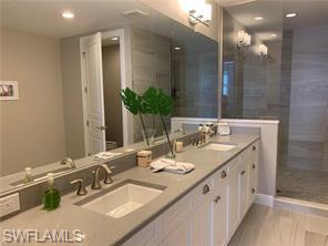 16390 Viansa Way, Unit 1202 Naples, FL 34110 - Photo 10 of 26 a bathroom with a sink double vanity and a mirror