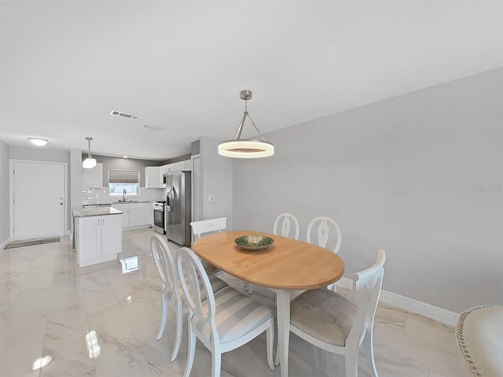 7 Dunoon Place, Unit 104 Dunedin, FL 34698 - Photo 12 of 45 a view of a dining room with furniture and wooden floor