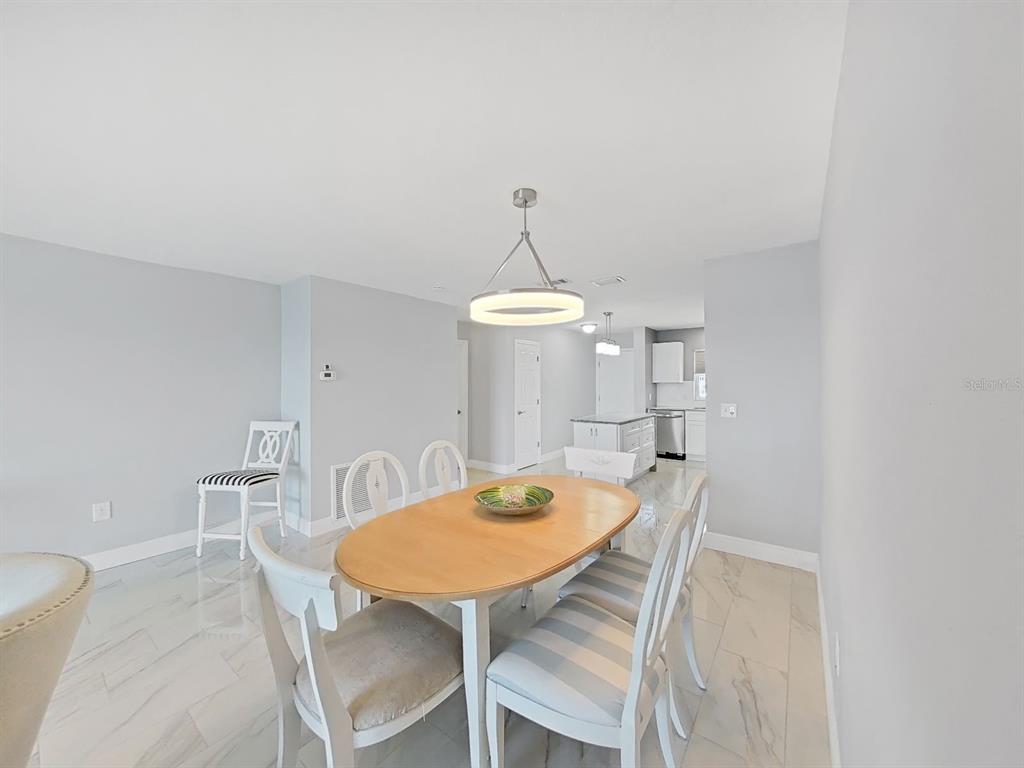 7 Dunoon Place, Unit 104 Dunedin, FL 34698 - Photo 13 of 45 a view of a dining room with furniture and wooden floor