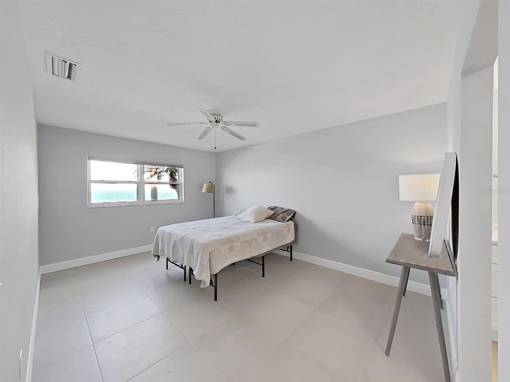 7 Dunoon Place, Unit 104 Dunedin, FL 34698 - Photo 25 of 45 a spacious bedroom with a bed and a window
