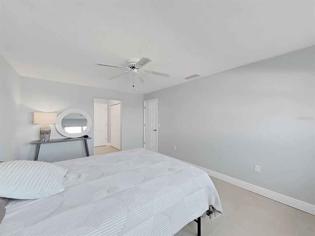 7 Dunoon Place, Unit 104 Dunedin, FL 34698 - Photo 27 of 45 a bedroom with a bed and a lamp