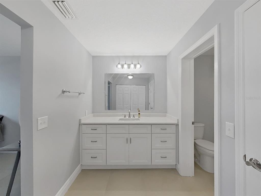 7 Dunoon Place, Unit 104 Dunedin, FL 34698 - Photo 29 of 45 a spacious bathroom with a double vanity sink and a mirror