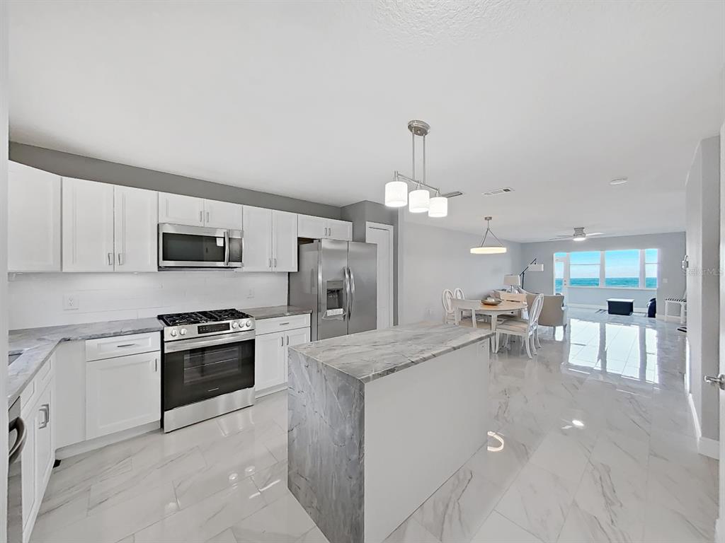 7 Dunoon Place, Unit 104 Dunedin, FL 34698 - Photo 3 of 45 a large kitchen with lots of counter space and appliances