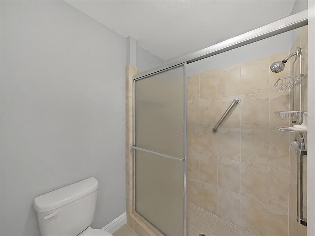 7 Dunoon Place, Unit 104 Dunedin, FL 34698 - Photo 31 of 45 a white toilet sitting next to a shower