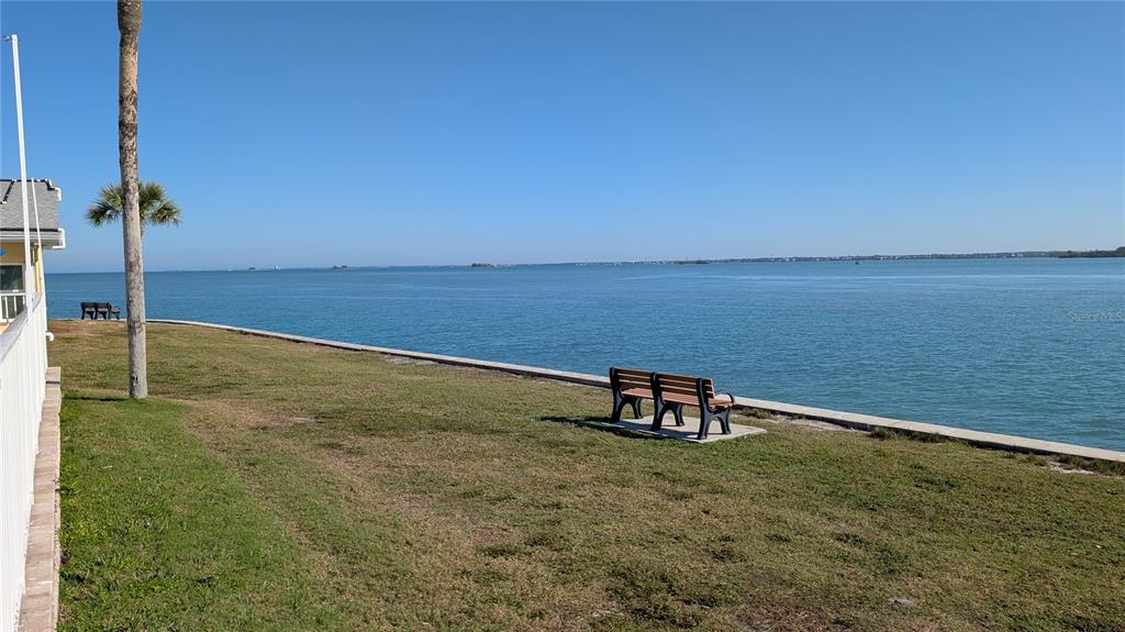 7 Dunoon Place, Unit 104 Dunedin, FL 34698 - Photo 38 of 45 a view of a lake with a bench in the background