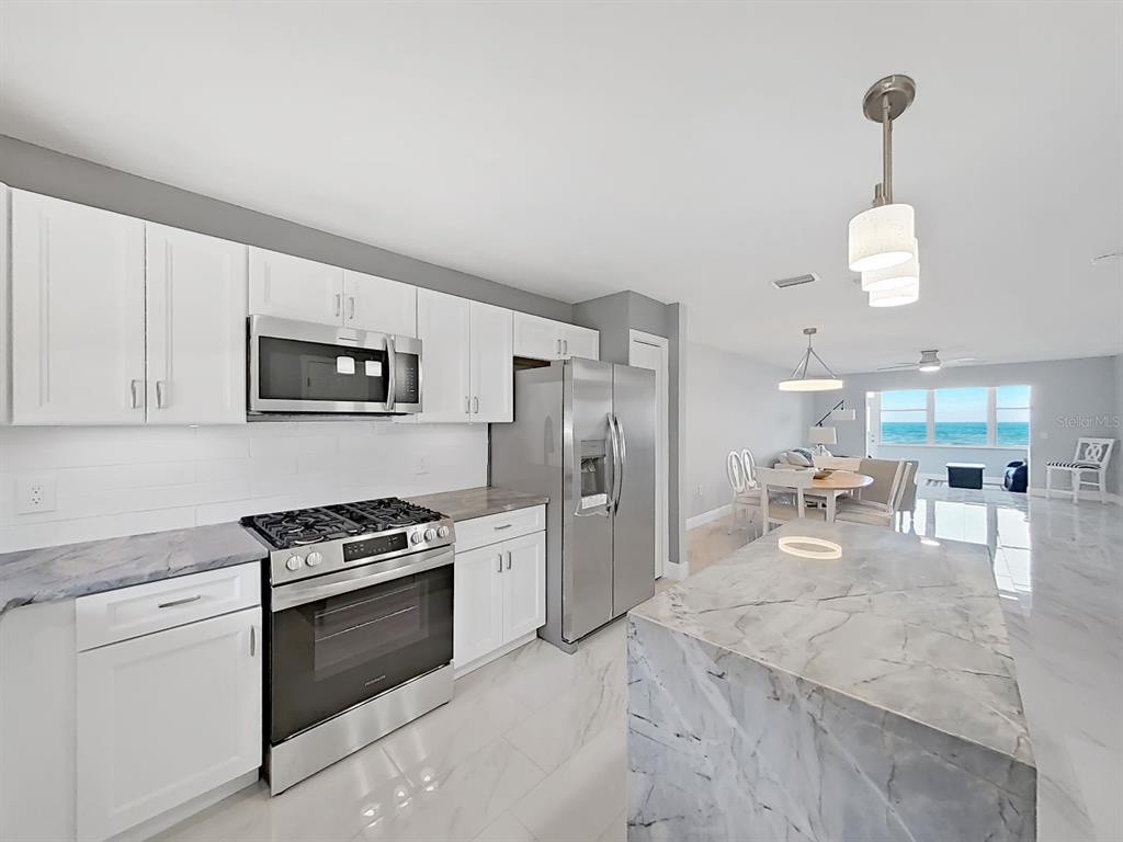 7 Dunoon Place, Unit 104 Dunedin, FL 34698 - Photo 4 of 45 a kitchen with stainless steel appliances granite countertop a sink stove and refrigerator