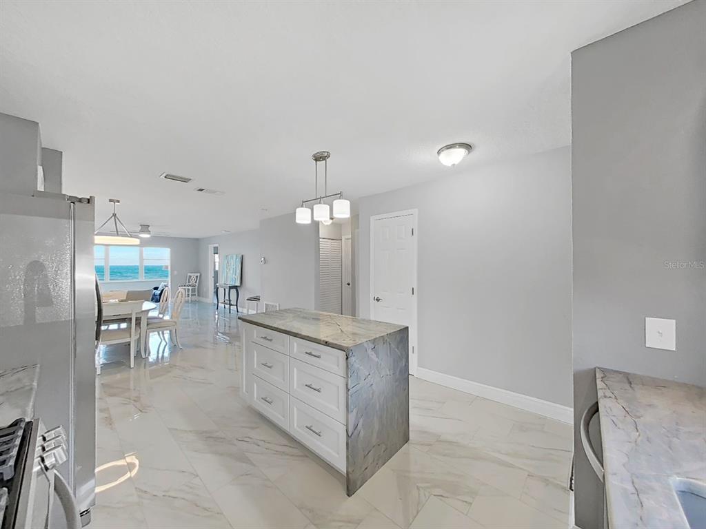 7 Dunoon Place, Unit 104 Dunedin, FL 34698 - Photo 9 of 45 a large kitchen with a lot of counter space and stainless steel appliances