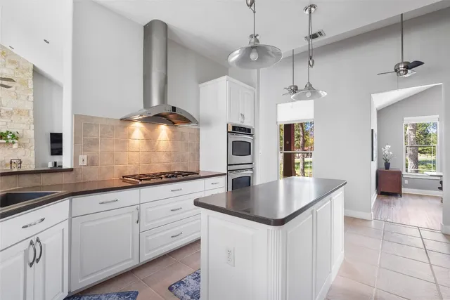 a kitchen with stainless steel appliances granite countertop a sink a refrigerator and a stove