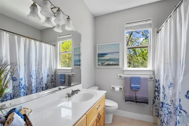 a bathroom with a sink a toilet and a mirror