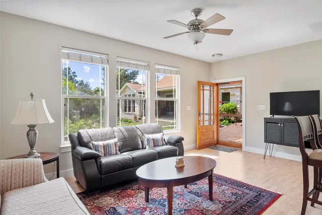 a living room with furniture a flat screen tv and a large window