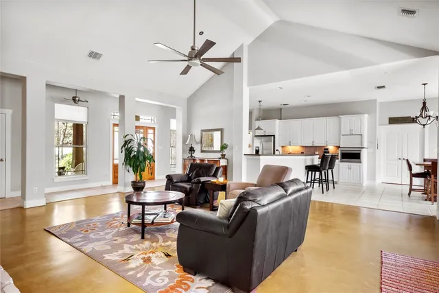 a living room with furniture and a view of kitchen