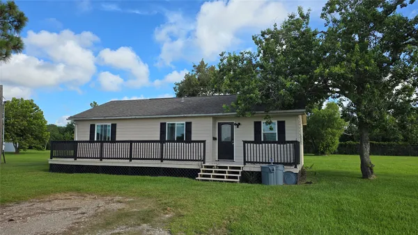 a view of a house with a yard and sitting area