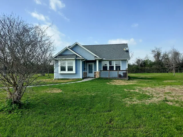 a view of a big yard with a large tree and a wooden fence