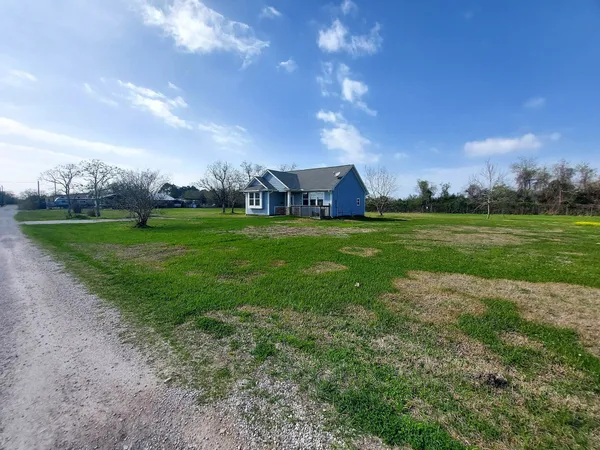 a view of a house with a yard and fence