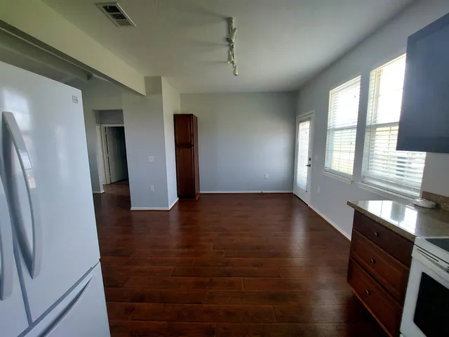 a view of a refrigerator in kitchen and wooden floor