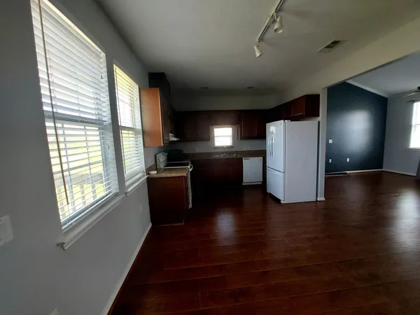 a kitchen with a wooden floor and a refrigerator