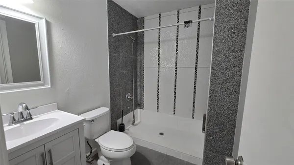 a bathroom with a granite countertop sink toilet and shower