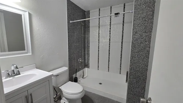 a bathroom with a granite countertop sink toilet and shower