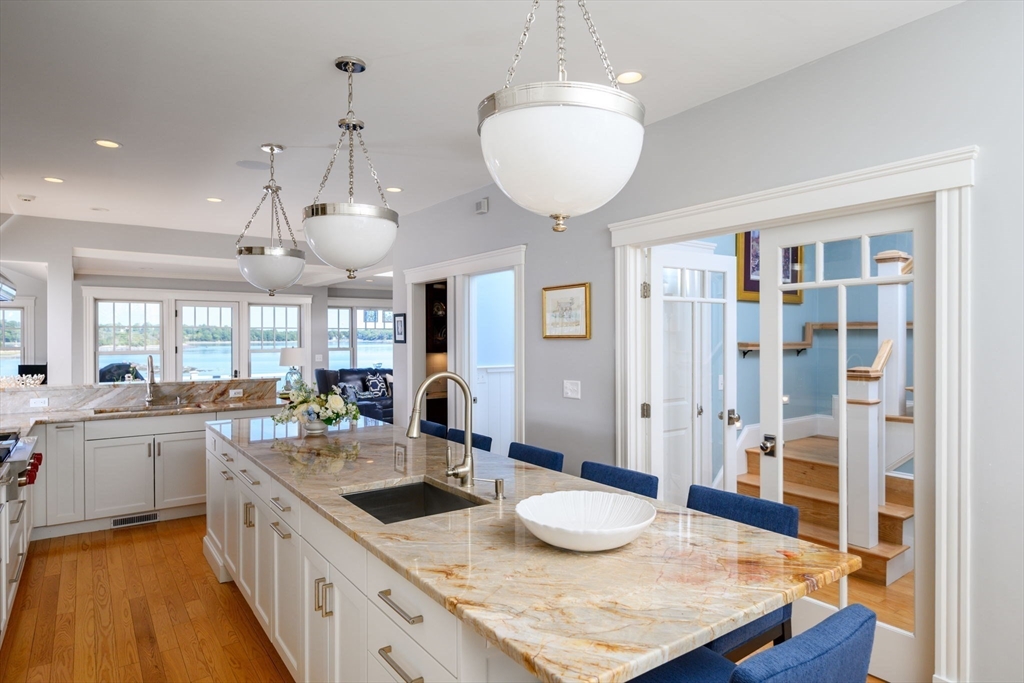 171 Otis Street Hingham, MA 02043 - Photo 9 of 29 a large kitchen with kitchen island a large counter space a sink appliances and living room view