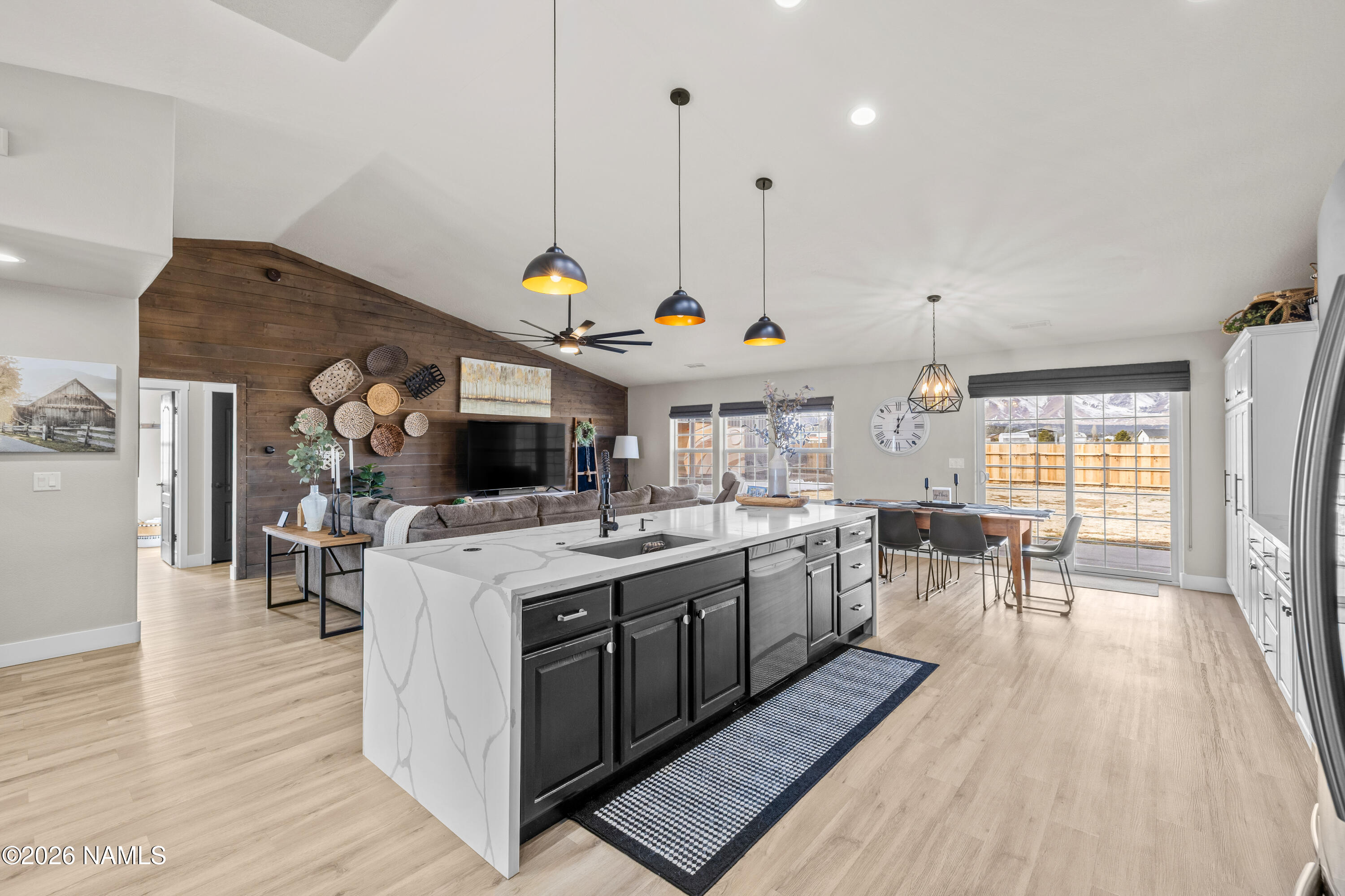 9534 North Aldrich Road Flagstaff, AZ 86004 - Photo 6 of 31 a open kitchen with stainless steel appliances granite countertop a stove top oven a sink dishwasher a dining table and chairs with wooden floor