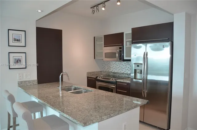 a bathroom with a granite countertop sink a toilet and a mirror