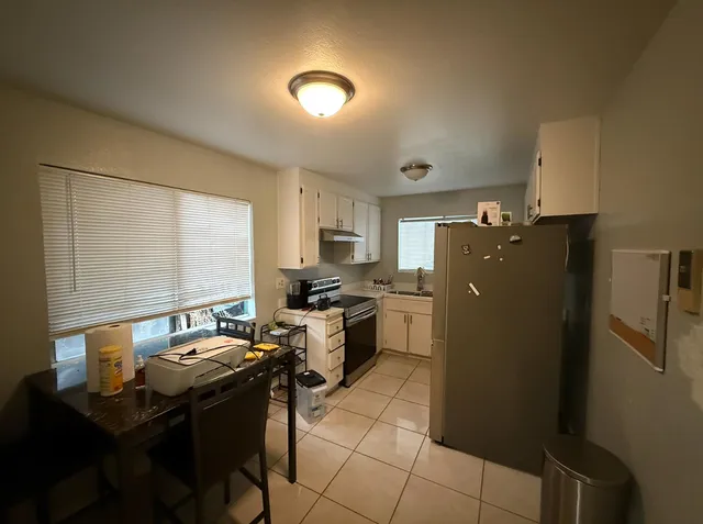 a kitchen with a sink refrigerator and cabinets