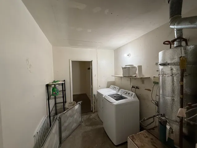 a room with water heater refrigerator washer and dryer