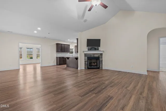 a view of a livingroom with a fireplace a flat screen tv and staircase