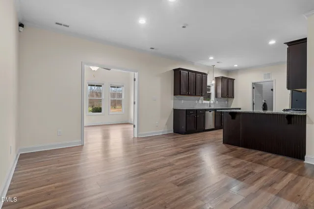 a kitchen with stainless steel appliances a stove a microwave and a hard wood floors