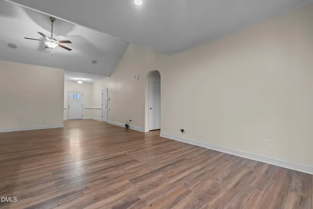 a view of a livingroom with a flat screen tv wooden floor and a ceiling fan