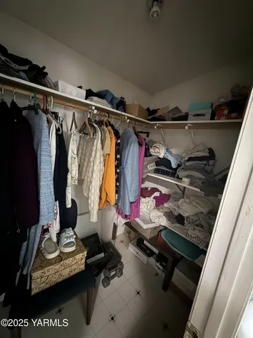 a view of walk in closet with clothes and shoes