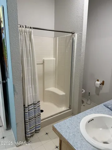 a bathroom with a sink a glass door shower and a mirror