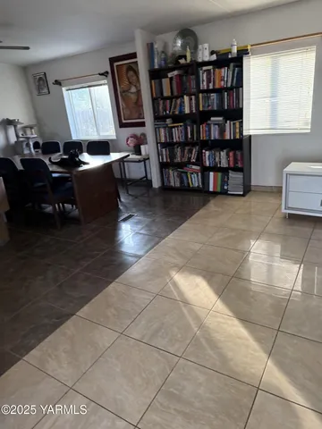 a living room with furniture a bookshelf and a window