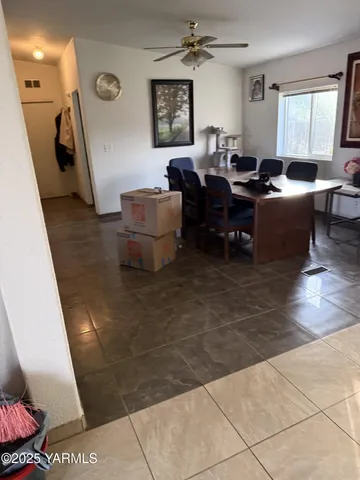 a living room with couches and kitchen view with wooden floor