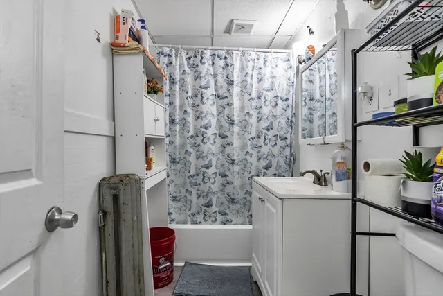 a bathroom with a sink and mirror with bathtub